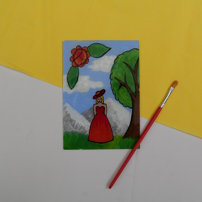 Das Motiv einer Frau und einem Baum vor einem bergigen Hintergrund ist auf einer Glasscheibe zu sehen.